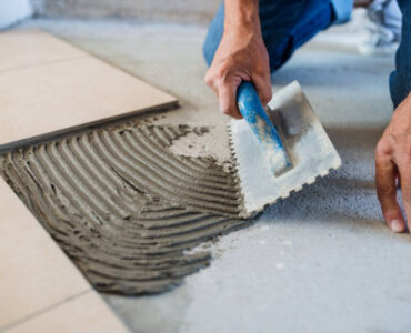 Unrecognizable old man working on interior of new house or flat.