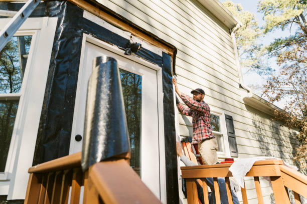 Father and son repair the siding of a colonial style house